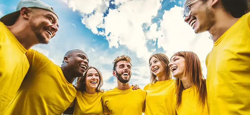 Collègues souriants posant ensemble lors d’un événement associatif, dans une ambiance conviviale