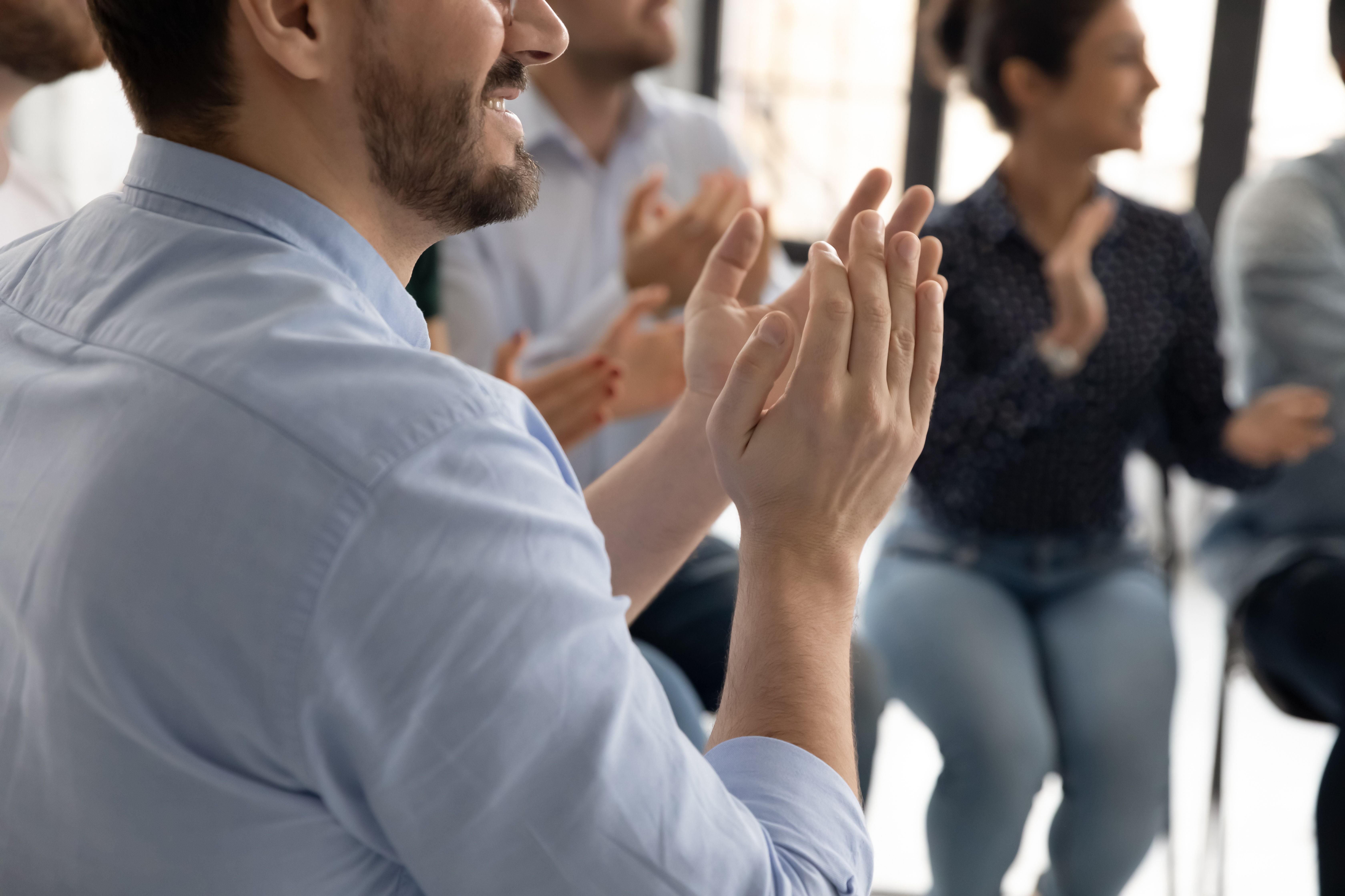 Des employées qui applaudissent leur collègue
